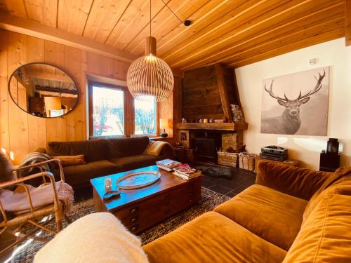 ein Wohnzimmer mit einem Sofa und einem Tisch in der Unterkunft Chalet Savoyard avec Cheminée et Parking à Samoëns - FR-1-624-80 in Samoëns