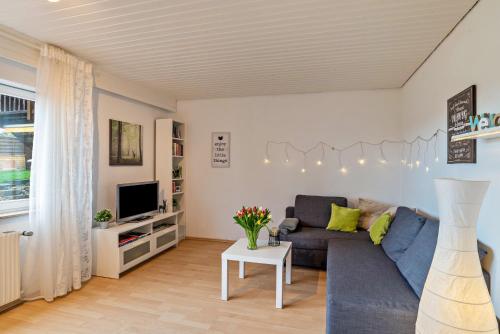 a living room with a blue couch and a tv at Wächtersberg in Wildberg