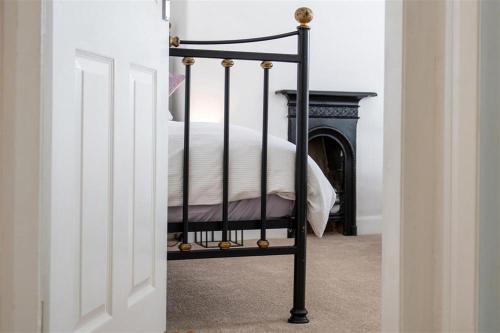 een bedframe van zwart metaal in een slaapkamer bij Lavender Terrace in Llandudno