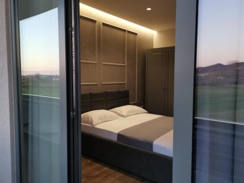 een slaapkamer met een bed en een glazen deur bij Te Aldo Hotel in Durrës