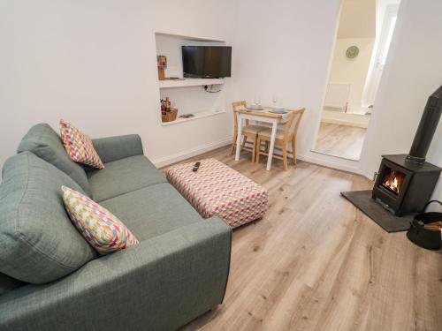 a living room with a couch and a wood stove at Tŷ Capel Bach in Bangor