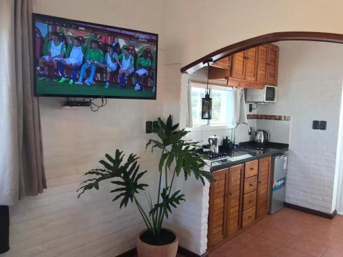 een keuken met een tv aan de muur bij El Diablo Chic Colonial in Punta Del Diablo