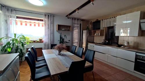 a kitchen with a wooden table and chairs in a room at Apartmaji Ri-100 in Portorož