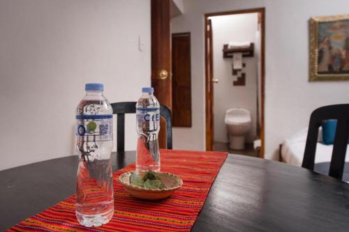 dos botellas de agua y un plato de comida en una mesa en CASA HOSPEDAJE EL LABRADOR, en Cusco