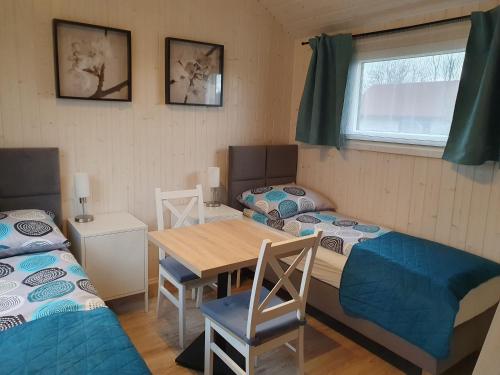 een kamer met 2 bedden en een tafel en stoelen bij Pokoje Babie Lato in Wrocław