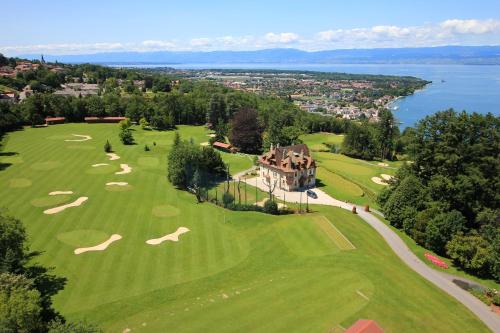 una vista aérea de un campo de golf con una casa en Le Manoir du Golf, en Publier