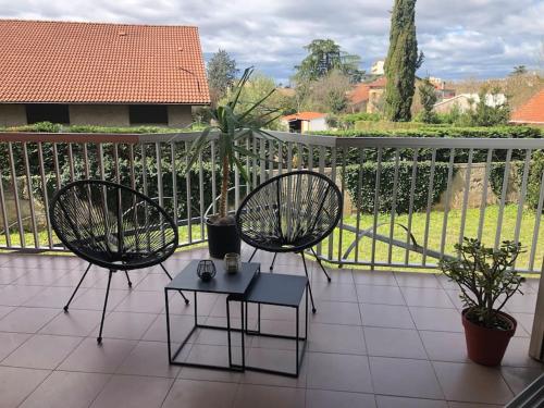 2 stoelen en een tafel op een balkon bij Studio Moderne, Terrasse et Parking in Romans-sur-Isère