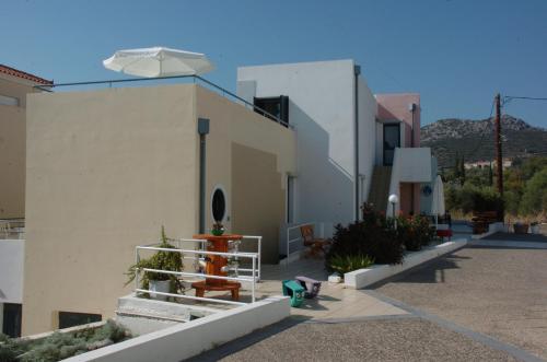 un edificio blanco con un paraguas encima en Blue Sky Hotel Apartments, en Tolo