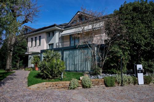 ein Haus mit einer steinernen Einfahrt davor in der Unterkunft Like Home Boutique Hotel in Azzano San Paolo