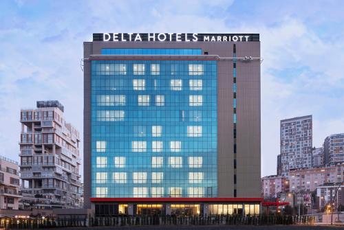 ein hohes Gebäude mit einem Schild darüber in der Unterkunft Delta Hotels by Marriott Istanbul Kagithane in Istanbul