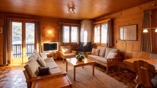 a living room with couches and a tv in a cabin at Stachelbeere OG in Fiesch