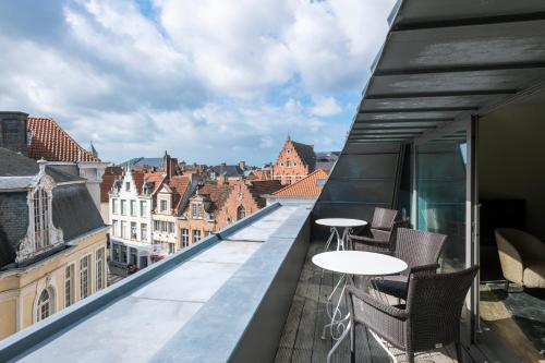 uma varanda com mesas e cadeiras e vista para os edifícios em Dukes' Apartments Grand Place - by Dukes' Hotel Collection em Bruges