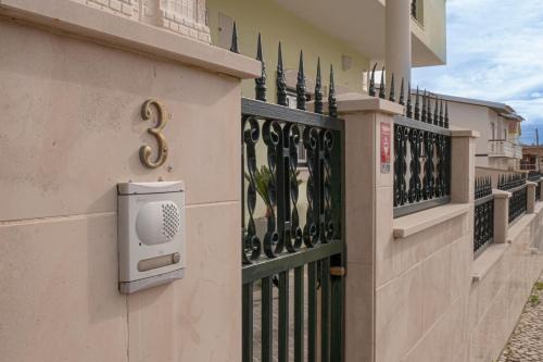 a building with a gate with a mailbox on it at Casa Fonte Nova in Nazaré