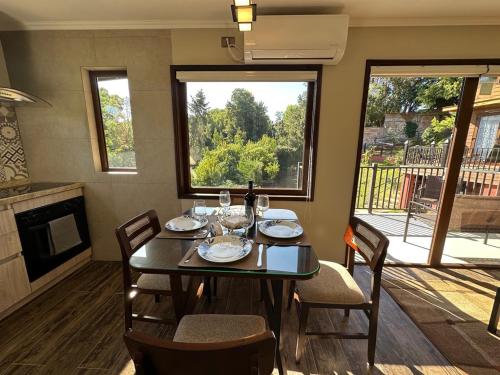 uma sala de jantar com uma mesa com cadeiras e uma lareira em Mirabosque aparment Ejecutivos 8 em Osorno