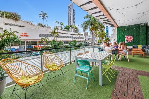 eine Terrasse mit einem Tisch und Stühlen auf dem Balkon in der Unterkunft Tequila Sunrise Hostel Surfers Paradise in Gold Coast