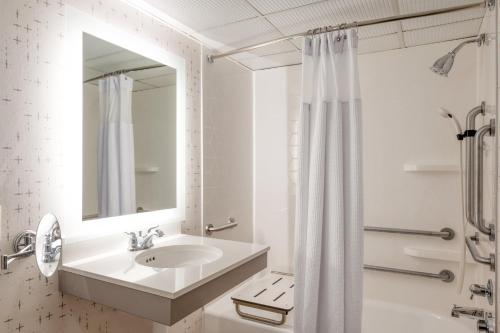 La salle de bains blanche est pourvue d'un lavabo et d'un rideau de douche. dans l'établissement Crowne Plaza Indianapolis-Airport, an IHG Hotel, à Indianapolis