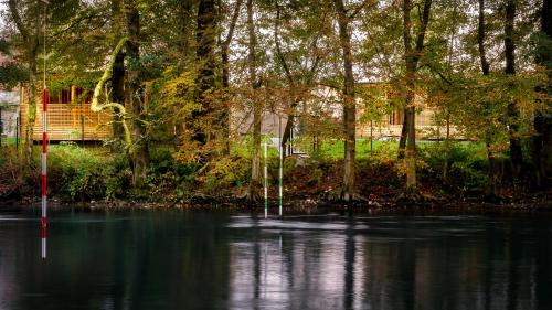 een rivier met bomen en een huis op de achtergrond bij Pearl of Sava Wild Waters in Ljubljana