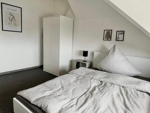 um quarto branco com uma cama grande e um armário em Ferienwohnung Flaming House Bitterfeld em Bitterfeld