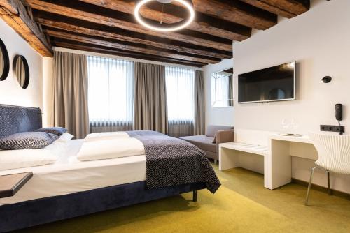 una camera con letto, scrivania e TV di Boutiquehotel am Dom a Salisburgo