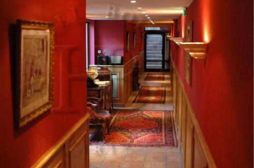 a hallway with red walls and a tile floor at Hotel Boileau in Paris