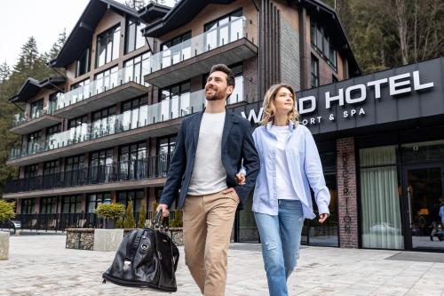 un homme et une femme marchant devant un hôtel dans l'établissement Wood Hotel Resort & SPA, à Bukovel