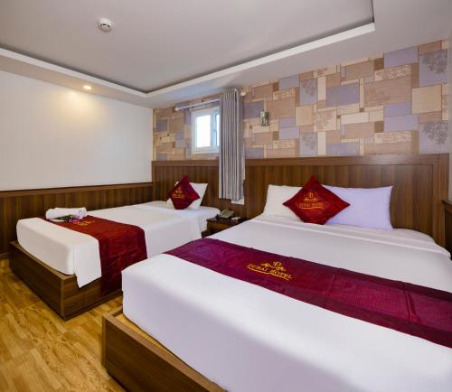 a hotel room with two beds and a window at Dubai Nha Trang Hotel managed by HT in Nha Trang