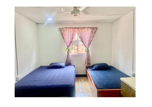 a bedroom with two beds and a window at Casa Cairo in Cartagena de Indias