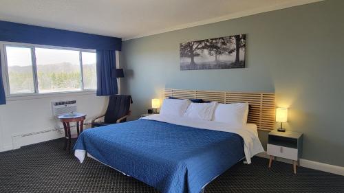 a hotel room with a bed and a window at Lord Nelson Motel in Kingston