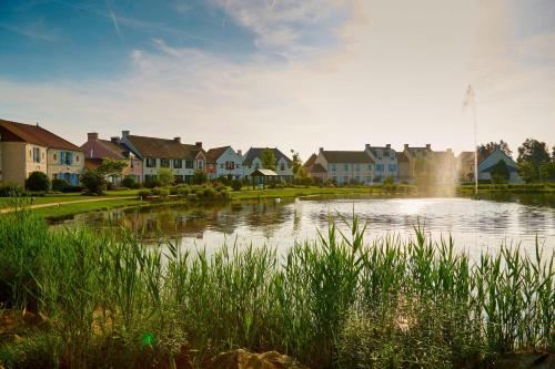 wioska z domami i jezioro w środku w obiekcie Marriott's Village d'Ile-de-France w mieście Bailly-Romainvilliers