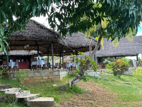 een gebouw met tafels en stoelen ervoor bij WINGS HOTELS in Nosy Be