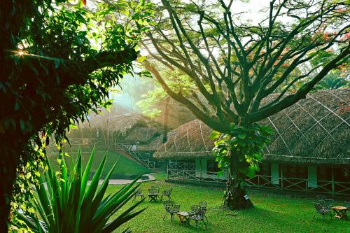 een gebouw met een grote boom in de tuin bij Spice Village Thekkady - a CGH Earth Experience in Thekkady