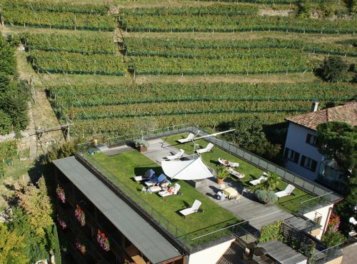 una vista sul soffitto di una casa con un prato attrezzato con tavoli e sedie di Hotel Sittnerhof a Merano