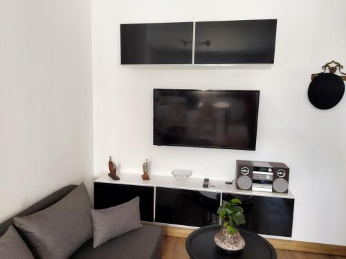 un soggiorno con divano e TV di Minimal apartment by the beach a Korinthos