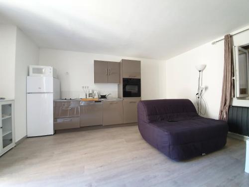 een woonkamer met een paarse bank en een keuken bij Maison Kyprea: charmant appartement /duplex , spacieux, tout confort avec terrasse extérieure privée, parking privatif , vue pittoresque sur la citadelle de Corté et les montagnes. in Corte