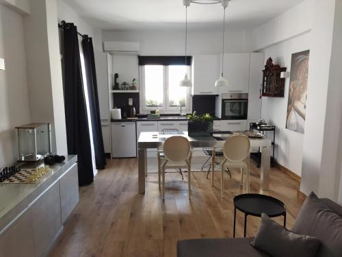 una cucina e un soggiorno con tavolo e sedie di Minimal apartment by the beach a Korinthos