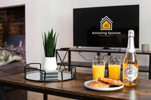 een tafel met een fles champagne en twee glazen jus d'orange bij Spacious 3 bed Terrace House with free parking & free Wi-Fi by Amazing Spaces Relocations Ltd in Saint Helens