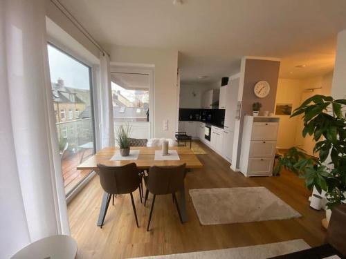 a living room with a table and chairs and a kitchen at Moderne Penthouse Wohnung in Schleswig