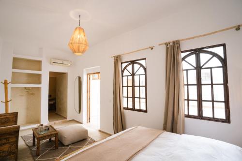 een slaapkamer met een bed en 2 ramen bij Riad Rahal in Marrakesh