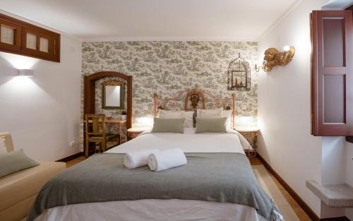 een slaapkamer met een groot bed en een spiegel bij Casa de S. Thiago de Obidos in Óbidos