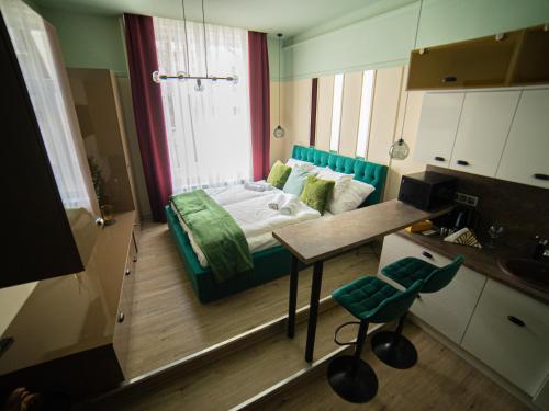 Cette petite chambre comprend un lit et une table. dans l'établissement Dream Apartments, à Szeged