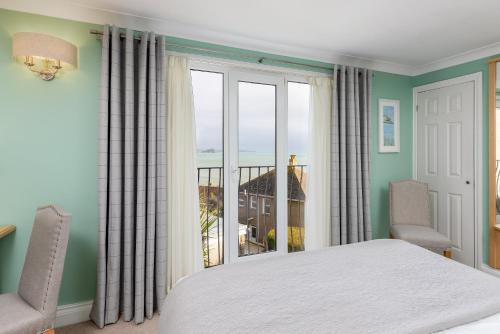 una camera con un letto e una grande finestra di Hotel Penzance a Penzance