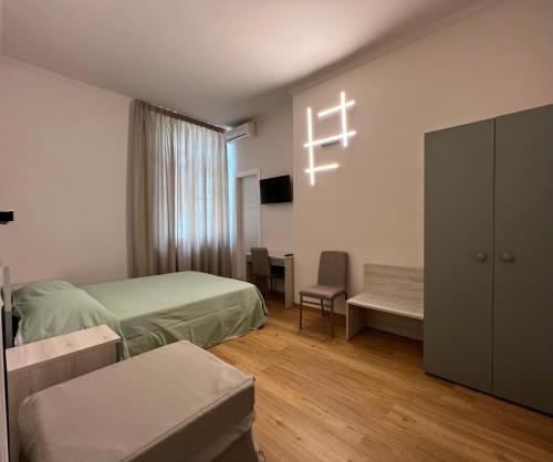 1 dormitorio con 2 camas y una cruz en la pared en Hotel Villa Primavera, en Pisa