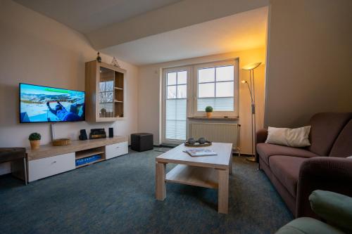 uma sala de estar com um sofá e uma televisão em Haus Kim Wohnung 2 em Büsum