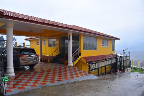 una casa amarilla con un coche aparcado delante de ella en Glen Premium Villa By LexStays, en Ooty