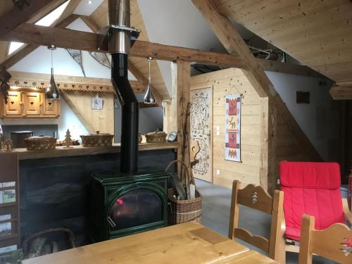 - un poêle à bois dans une chambre avec une table dans l'établissement Chambre d'hôtes Carélie et Laponie, à Orbey