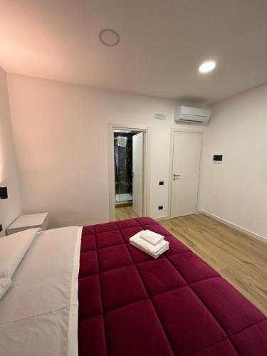 um quarto com uma grande cama vermelha com duas toalhas em Dalmazia 33 em Salerno