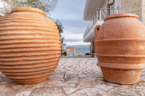 dos jarrones grandes sentados en un lado de un edificio en Villa Athina, en Preveza