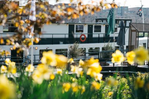 un bateau dans un port avec des fleurs jaunes dans l'établissement Botel Maastricht, à Maastricht