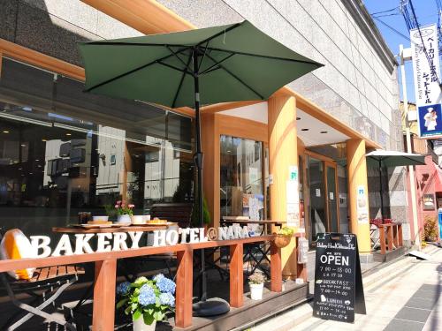 een restaurant met een groene paraplu ervoor bij Bakery Hotel Chateau D'or in Nara