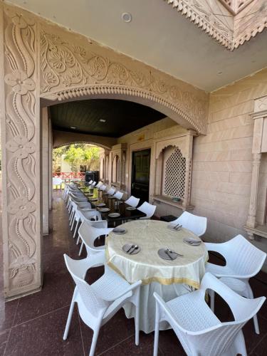 a row of white tables and chairs in a restaurant at Namanbagh in Alwar